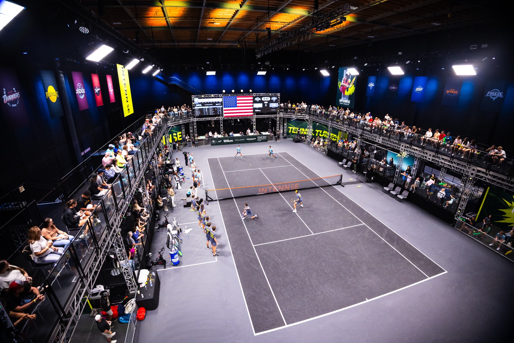 Wide view of the INTENNSE Arena in Atlanta during a match, court lit and stands full.